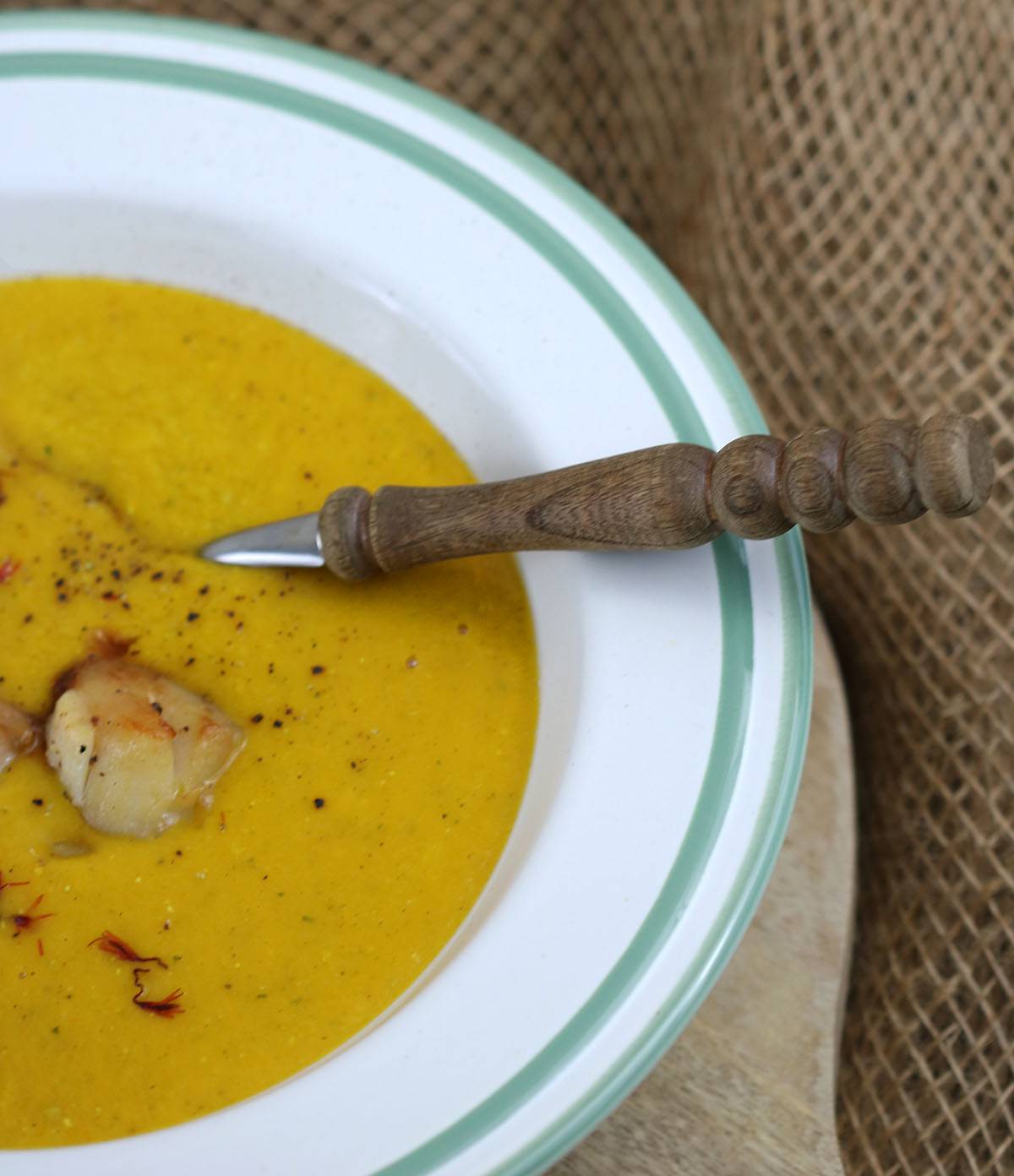 Cremige Currysuppe mit Garnelen im Teller